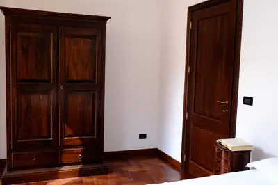 a bedroom with a wooden cabinet and a bed at Maison al Massimo - City Center Full Apartment in Palermo