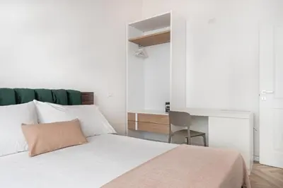 a bedroom with a white bed and a desk at La Terrazza su Dante Rooms in Palermo