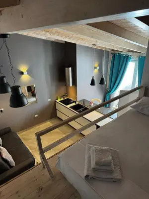 a loft bed in a room with a kitchen at La Piazzetta a Mare Holiday House in Sferracavallo