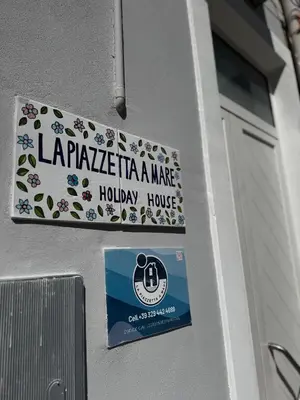 a sign on the side of a house at La Piazzetta a Mare Holiday House in Sferracavallo