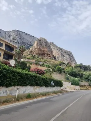 an empty road with a mountain in the background at Onda blu in Carini
