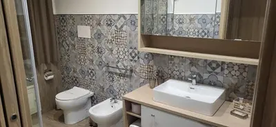 a bathroom with a toilet and a sink and a mirror at De Luca in Palermo