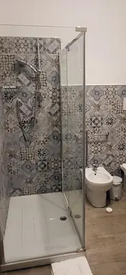 a bathroom with a shower with a sink and a toilet at De Luca in Palermo