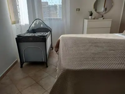 a bedroom with a baby crib sitting next to a bed at D'Amelio Sweet Home in Palermo