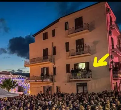 a large crowd of people standing in front of a building at La casa sulla piazza in Cerda