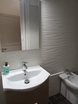 a bathroom with a sink and a mirror and a toilet at La casa sulla piazza in Cerda