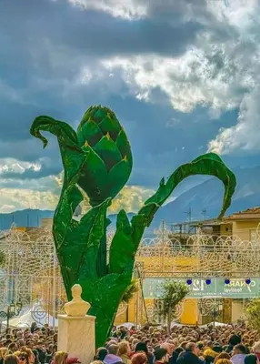 a crowd of people standing around a green sculpture at La casa sulla piazza in Cerda