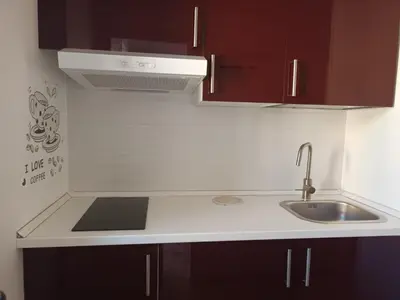 a kitchen with brown cabinets and a sink at La casa sulla piazza in Cerda