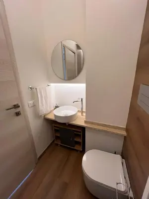 a bathroom with a white toilet and a mirror at LaPignaVerde in Palermo