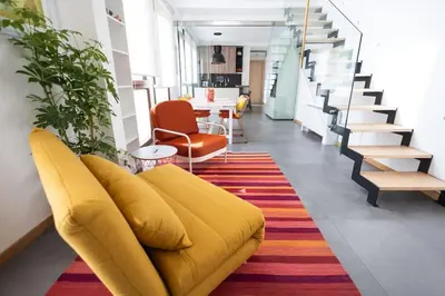 a living room with a yellow couch and a colorful rug at iFlat Corte Seralcadi in Palermo