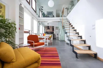 a living room with a yellow couch and a staircase at iFlat Corte Seralcadi in Palermo