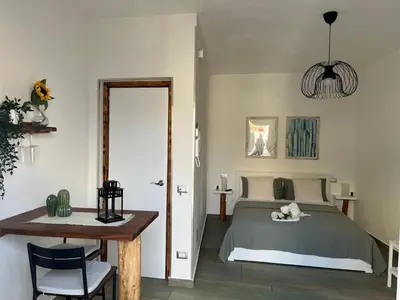a bedroom with a bed and a table and a table sidx sidx sidx at Casa vacanze green house in Terrasini
