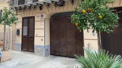 an entrance to a building with an orange tree at Casa Patry in Palermo