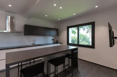 a kitchen with a bar with chairs and a window at Villa Tina Mondello in Mondello