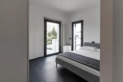 a bedroom with a bed and large glass windows at Villa Tina Mondello in Mondello