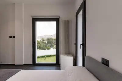 a bedroom with a bed and a large window at Villa Tina Mondello in Mondello
