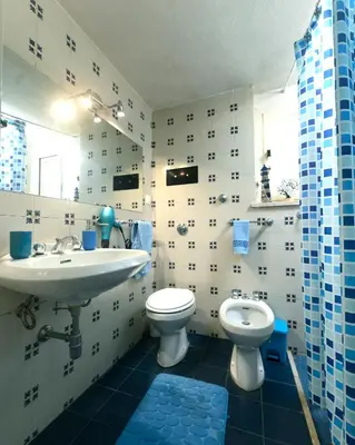a blue and white bathroom with a sink and a toilet at Villa Rosa Mondello in Mondello