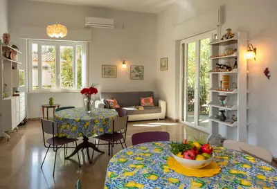 a living room with two tables and a couch at Villa Rosa Mondello in Mondello