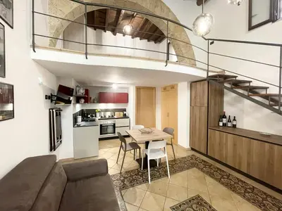 a living room and kitchen with a table and a couch at I due archi in Bagheria