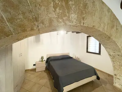 a bedroom with a bed and an archway at I due archi in Bagheria