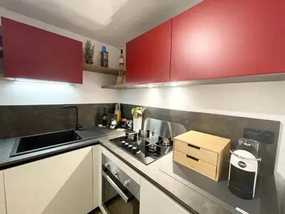 a small kitchen with red cabinets and a sink at I due archi in Bagheria