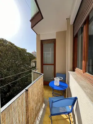 a balcony with two blue chairs and a table at LaPignaVerde Suites in Palermo