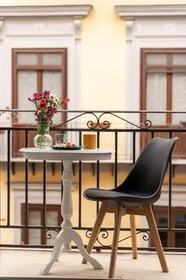 a table with a chair and a vase of flowers on a balcony at 145 Maqueda Palermo in Palermo
