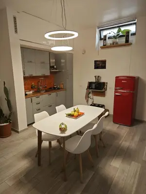 a kitchen with a white table and chairs and a red refrigerator at Teresita in Monreale