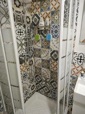 a shower in a bathroom with a tiled wall at Teresita in Monreale