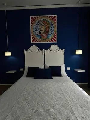 a blue bedroom with a large bed with blue walls at Casa Vacanze Tirreno in Trabia