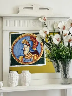 a painting on a mantle with a vase of flowers at Casa Vacanze Tirreno in Trabia