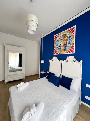 a bedroom with a large bed with blue walls at Casa Vacanze Tirreno in Trabia