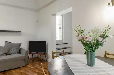 a living room with a vase of flowers on a table at GuestHost - Vucciria & La Cala Lovely Apartment with Terrace in Palermo