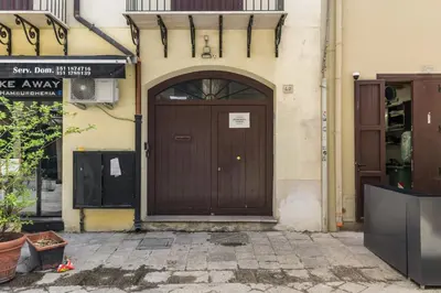 a brown door on the side of a building at GuestHost - Vucciria & La Cala Lovely Apartment with Terrace in Palermo