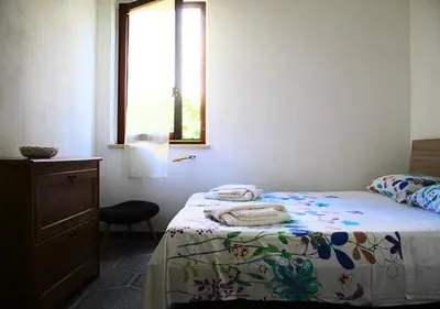 a bedroom with a bed with a dresser and a window at Villa Giorgia in Alcamo