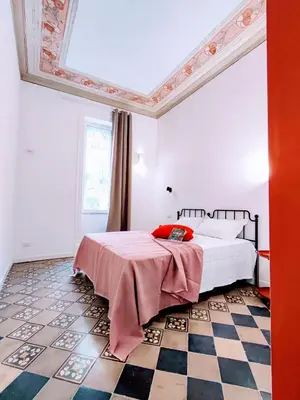 a bedroom with a bed and a checkered floor at Donna Oliva Guest House in Palermo