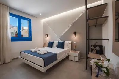 a bedroom with a bed with blue pillows at Bed and Breakfast Da Francesca in Castelluzzo