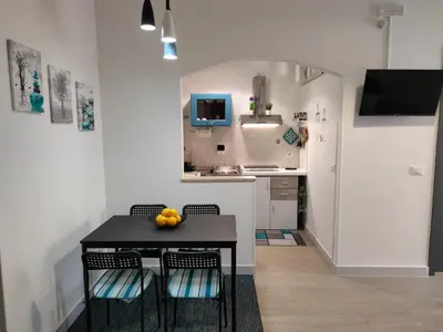 a kitchen with a black table with chairs and a television at Casa Magarìa in Palermo
