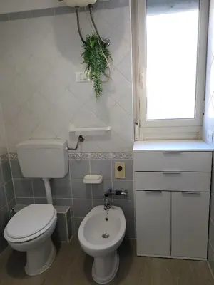 a bathroom with a toilet and a sink and a window at Casa Magarìa in Palermo