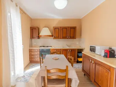 a kitchen with a table with chairs and a microwave at Casa Vacanze La Dolce Vita in Mandra Capreria