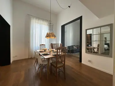a dining room with a table and chairs and a mirror at Laura's Apartment in Palermo