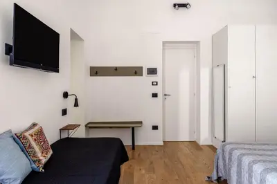 a bedroom with a bed and a desk and a tv at Azizò, la Verde in Palermo