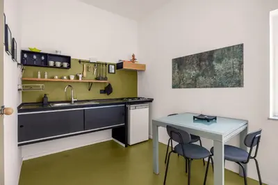 a kitchen with a sink and two chairs and a table at Azizò, la Verde in Palermo