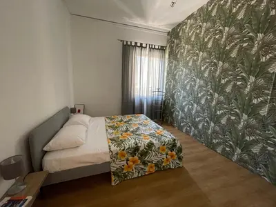 a bedroom with a bed with a floral patterned wall at Appartamento vicino il centro in Palermo