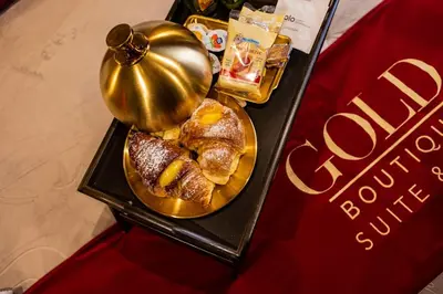 a table with a plate of pastries and a bell at GOLD Suite&SPA in Palermo