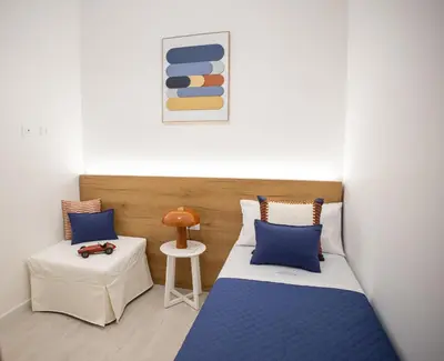 a room with two beds and a table with a stool at Casa Grazia in Partinico