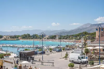 a beach with a van parked in a parking lot at Casetta al Molo di Mondello by Wonderful Italy in Palermo