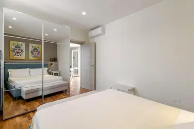 a bedroom with a large white bed and a mirror at GuestHost - Palermo's Rooftop - Apt with Panoramic Terrace in Palermo