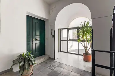 a hallway with a green door and potted plants at GuestHost - Palermo's Rooftop - Apt with Panoramic Terrace in Palermo