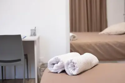 two towels on a bed in a hotel room at Villa due Scale in Palermo